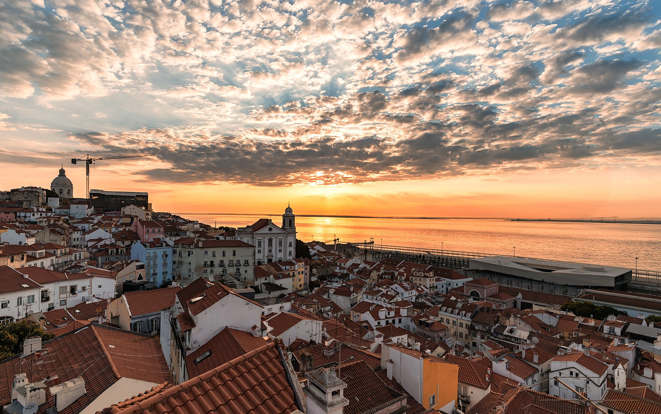 View of Lisbon's Alfama neighborhood and Tagus river from Portas do Sol viewpoint.
