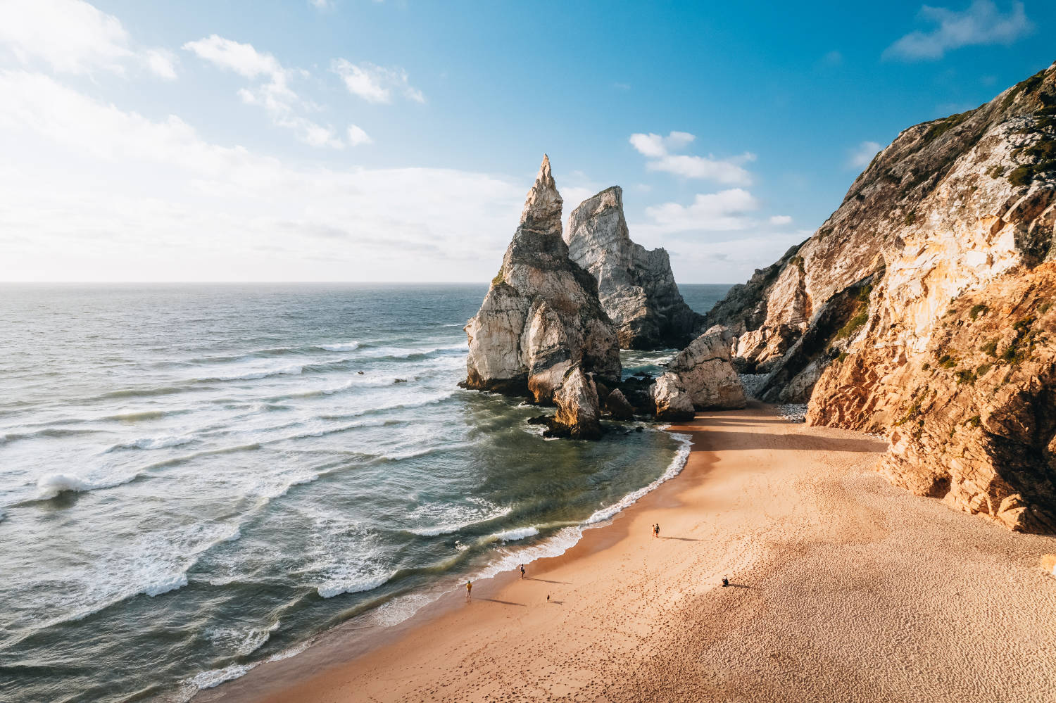 Praia da Ursa beach with striking rock formations and rough waves.